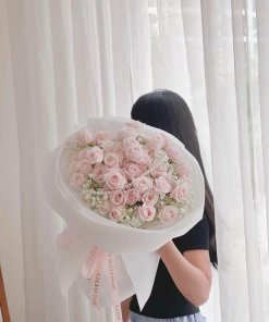 Bó hoa hồng phấn tinh tế kết hợp hoa baby trắng, được gói giấy sang trọng và ruy băng "LOVE IS ETERNAL", do STflowers thiết
