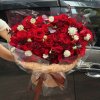 Bó hoa hồng đỏ rực rỡ sang trọng được gói cẩn thận, điểm xuyết hoa trắng nhỏ và lá phụ, thể hiện tình yêu nồng cháy. Đặt hoa