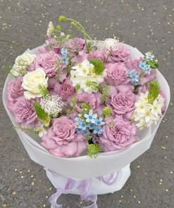 Bó hoa hồng tím lavender chủ đạo, kết hợp hoa trắng, xanh dương tinh tế, gói trắng sang trọng từ STflowers Quận 7.