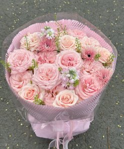 Bó hoa hồng phấn tươi thắm, ngọt ngào với nhiều cánh hoa nở rộ, điểm xuyết lá xanh, được gói ghém tinh tế, sẵn sàng giao tại