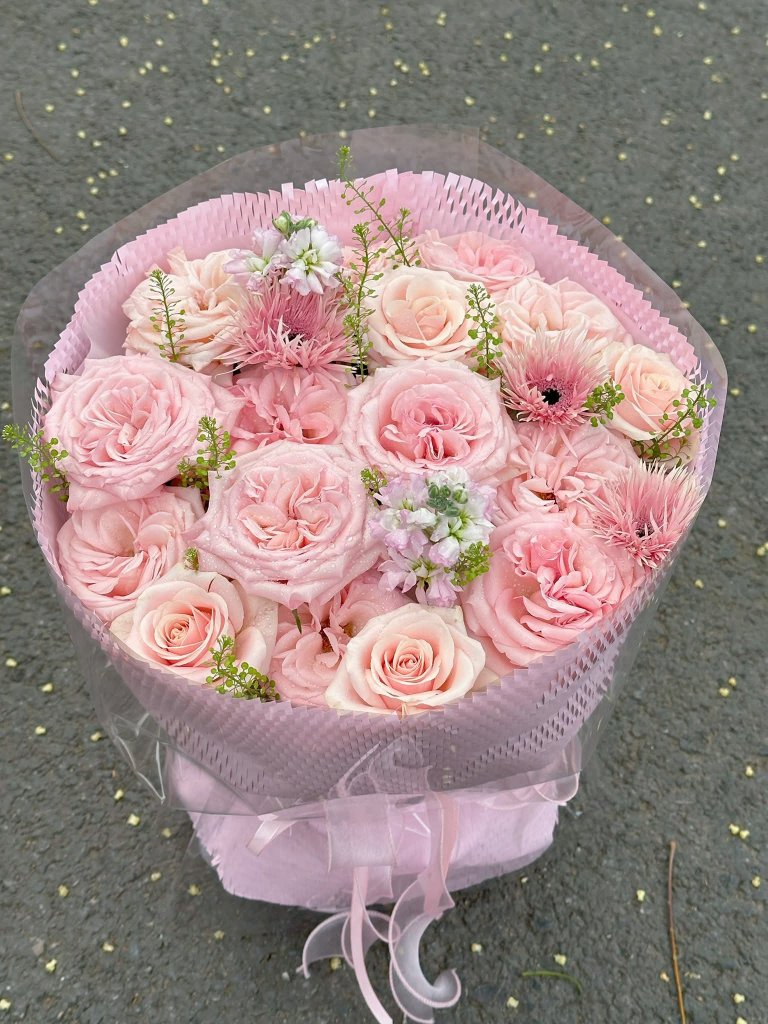 Bó hoa hồng phấn tươi thắm, ngọt ngào với nhiều cánh hoa nở rộ, điểm xuyết lá xanh, được gói ghém tinh tế, sẵn sàng giao tại