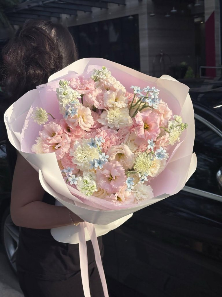 Bó hoa pastel dịu dàng với sắc hồng, trắng và xanh baby, được gói tinh tế, phù hợp làm quà tặng ý nghĩa từ STflowers Quận 7.