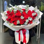Bó hoa hồng đỏ rực rỡ gói giấy trắng tinh tế cùng lá eucalyptus xanh xám, quà tặng ý nghĩa từ STflowers tại TP.HCM. Thể hiện tình yêu nồng cháy.