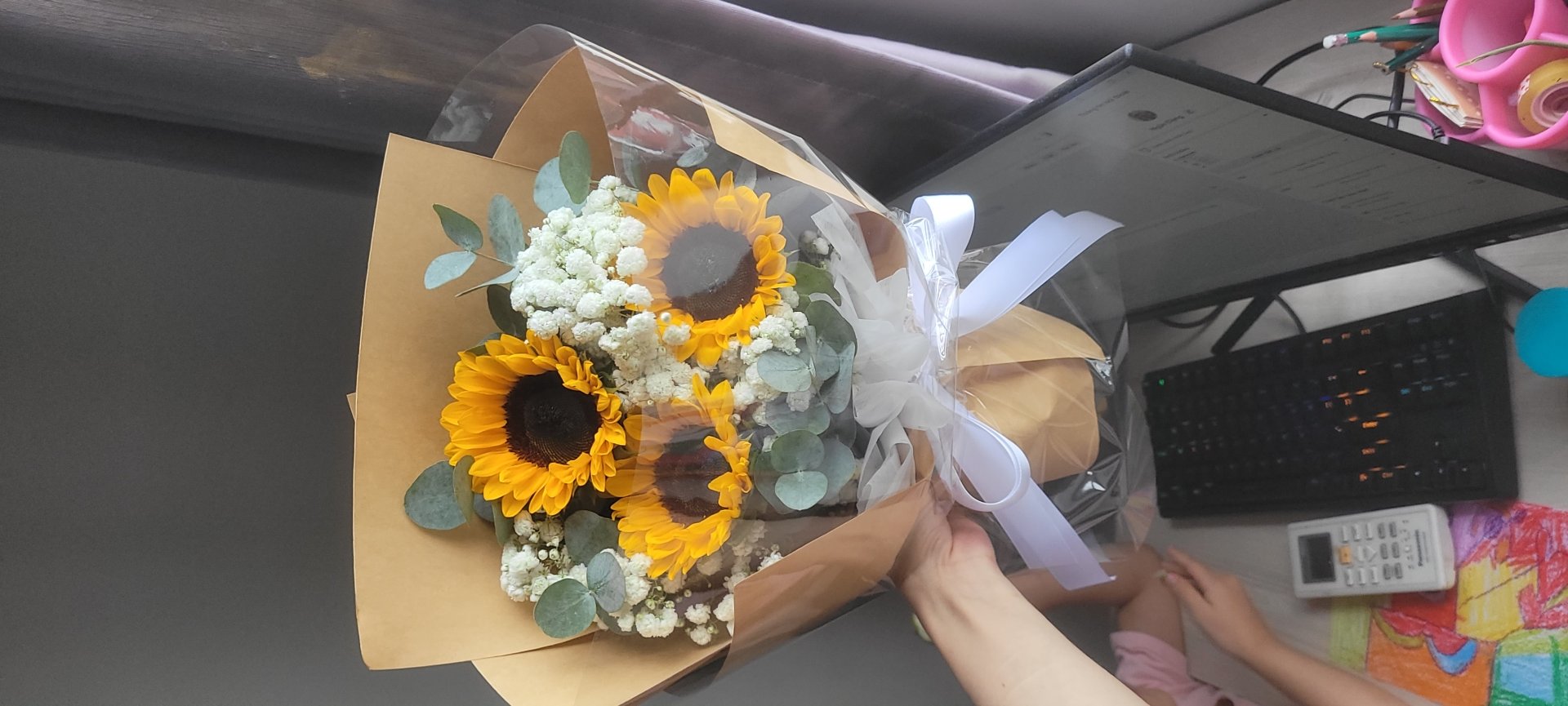 Bó hoa hướng dương tươi thắm kết hợp hoa baby trắng tinh khôi, gói giấy kraft nâu và nilon trong suốt, buộc nơ trắng sang trọng từ STflowers.