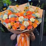 Bó hoa tươi tone cam rực rỡ gói giấy hiện đại kèm nơ chữ tại STflowers Quận 7