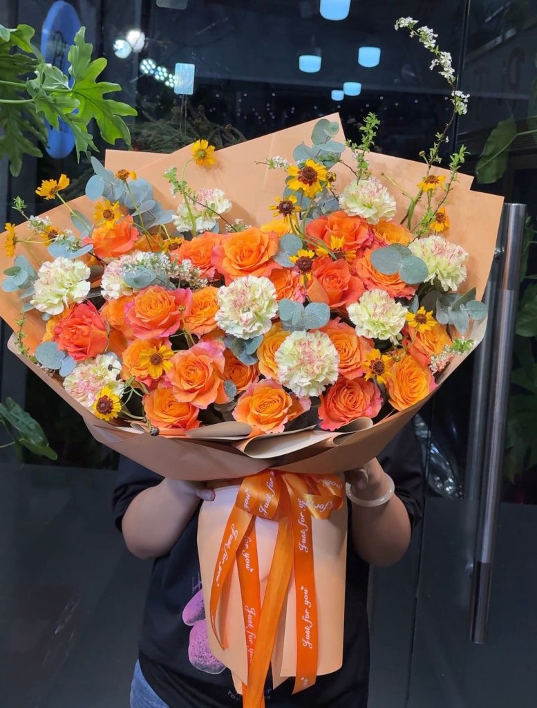 Bó hoa tươi tone cam rực rỡ gói giấy hiện đại kèm nơ chữ tại STflowers Quận 7