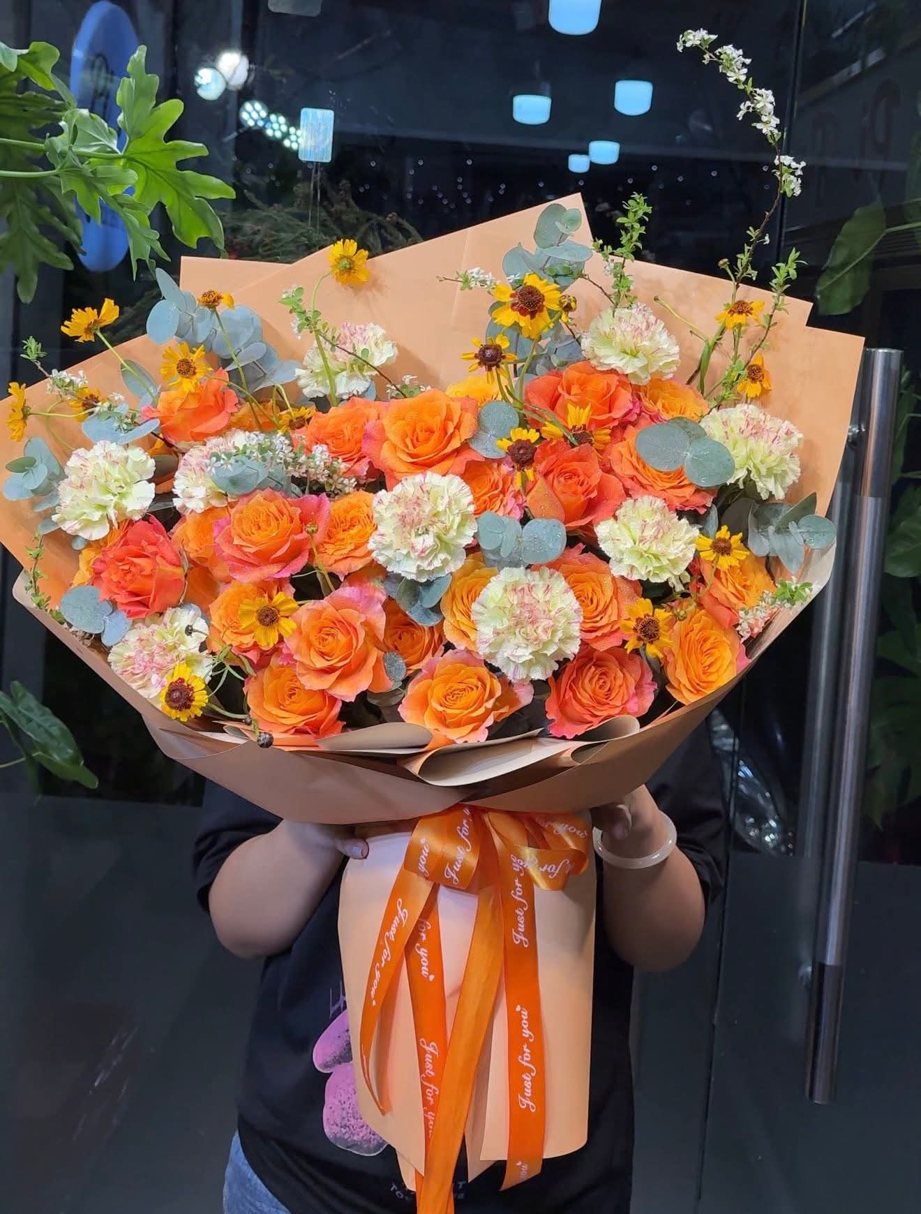 Bó hoa tươi tone cam rực rỡ gói giấy hiện đại kèm nơ chữ tại STflowers Quận 7