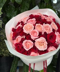 Bó hoa hồng đỏ và hồng pastel tươi rói, có giọt sương, gói giấy trắng tinh tế từ STflowers Quận 7, thể hiện sự lãng mạn và sang trọng.