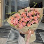 Bó hoa hồng pastel thanh lịch được gói giấy kraft và ruy băng hồng, món quà ý nghĩa từ STflowers Quận 7, TP.HCM.