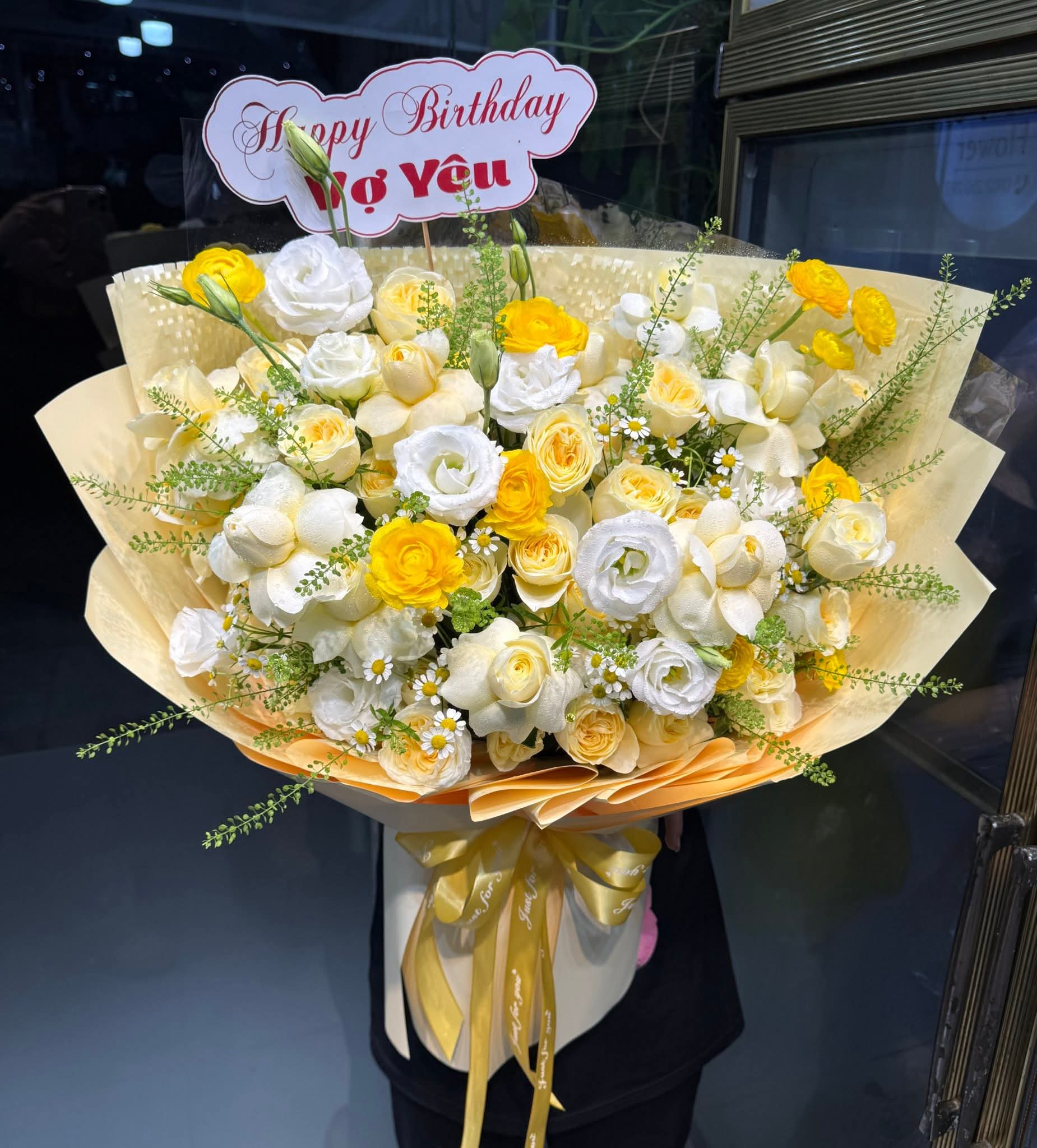 Bó hoa sinh nhật đẹp tặng vợ yêu với hoa hồng, lisianthus và ranunculus tone vàng trắng tinh khôi, gói giấy thanh lịch từ STflowers Quận 7.
