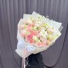 Bó hoa tươi tone hồng pastel và trắng, gói giấy sang trọng với nơ trắng lớn, trang trí ruy băng, của STflowers tại Quận 7, TP.HCM.