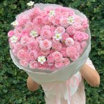 Một bó hoa hồng phấn lớn, thanh lịch được gói giấy trắng tinh tế, điểm xuyết hoa nhỏ trắng, đang được STflowers cung cấp tại TP.HCM.
