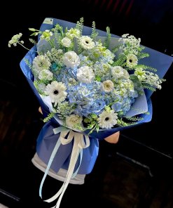 Bó hoa tươi xanh trắng thanh lịch với cẩm tú cầu và đồng tiền trắng, gói giấy xanh dương tại STflowers Quận 7.