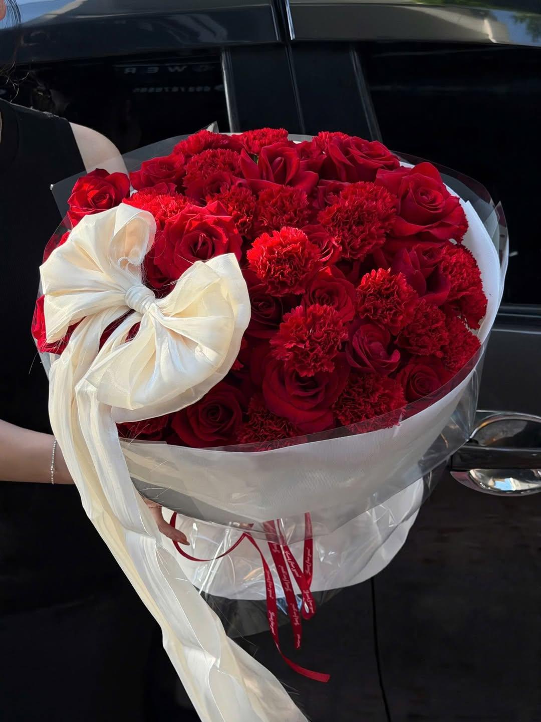 Bó hoa hồng đỏ sang trọng được gói nơ kem tại shop hoa tươi STflowers Quận 7